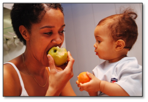 Baby and Mother eating pieces of fruit