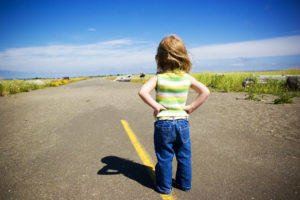 girl standing on a road looking towards the future