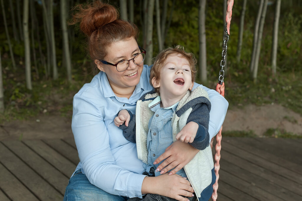 a child with a disability is on a swing with his mother